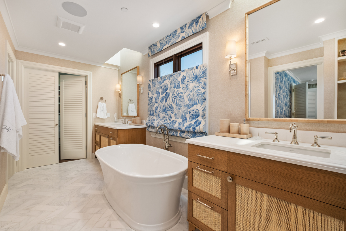 Primary bath with rift-oak and cane double vanity, freestanding tub